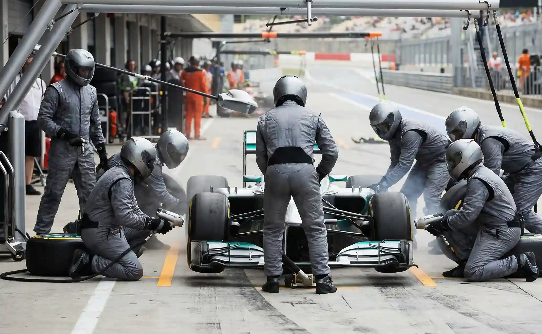 F1 pitstop met monteurs die banden wisselen in actie